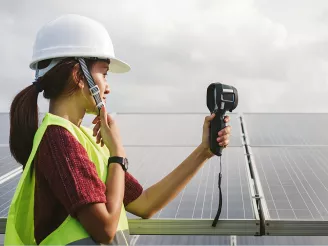 woman holding a heat camera at PV panels